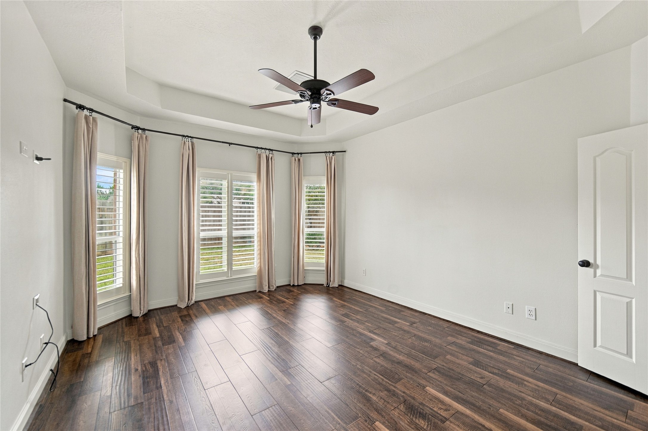 On to the primary suite where you will find a tray ceiling, abundant natural light, and additional plantation shutters!
