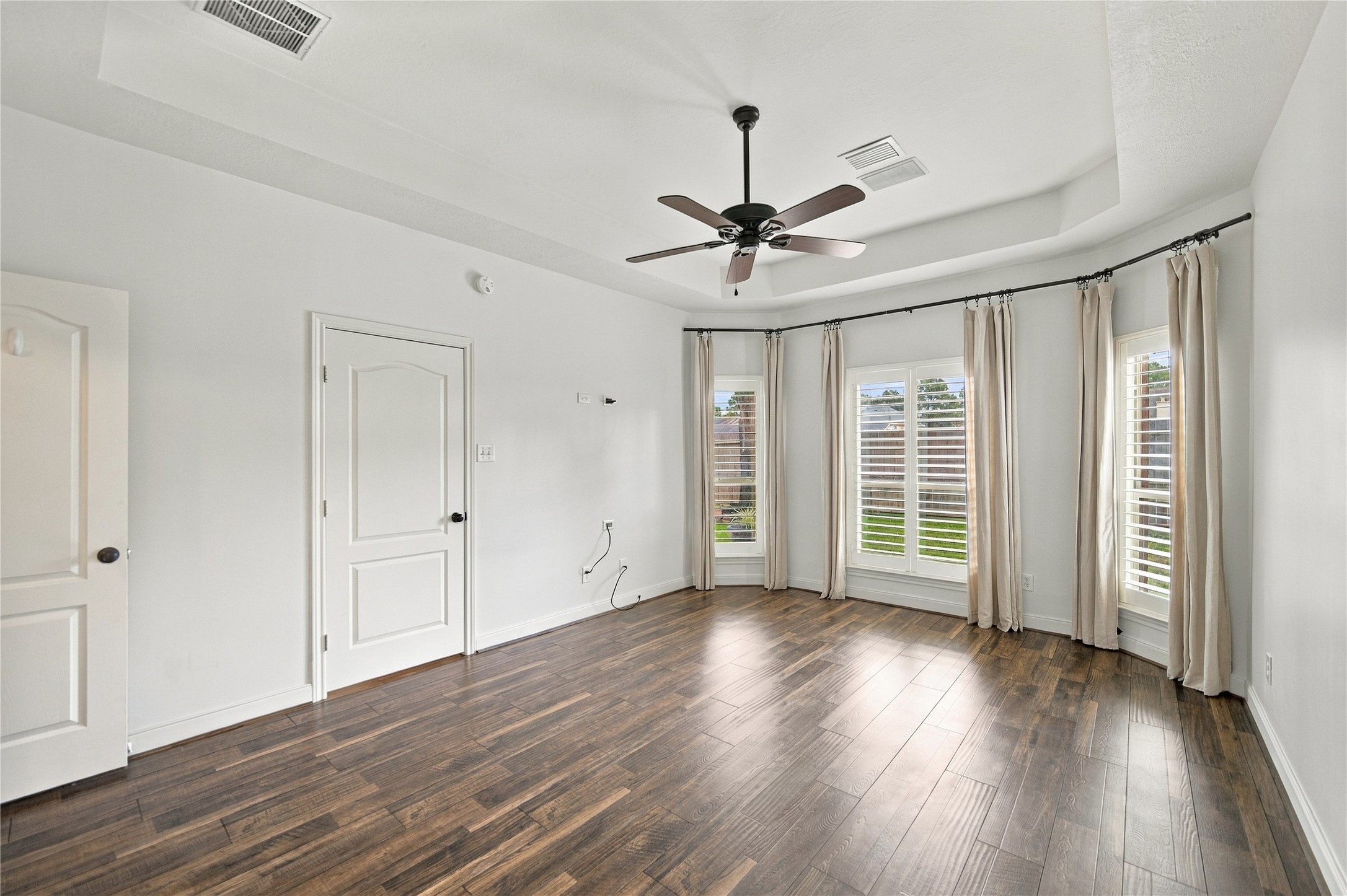 This spacious primary bedroom is further complemented by gleaming floors and a ceiling fan.  There's plenty of room for any-size bed and whatever furniture you like!