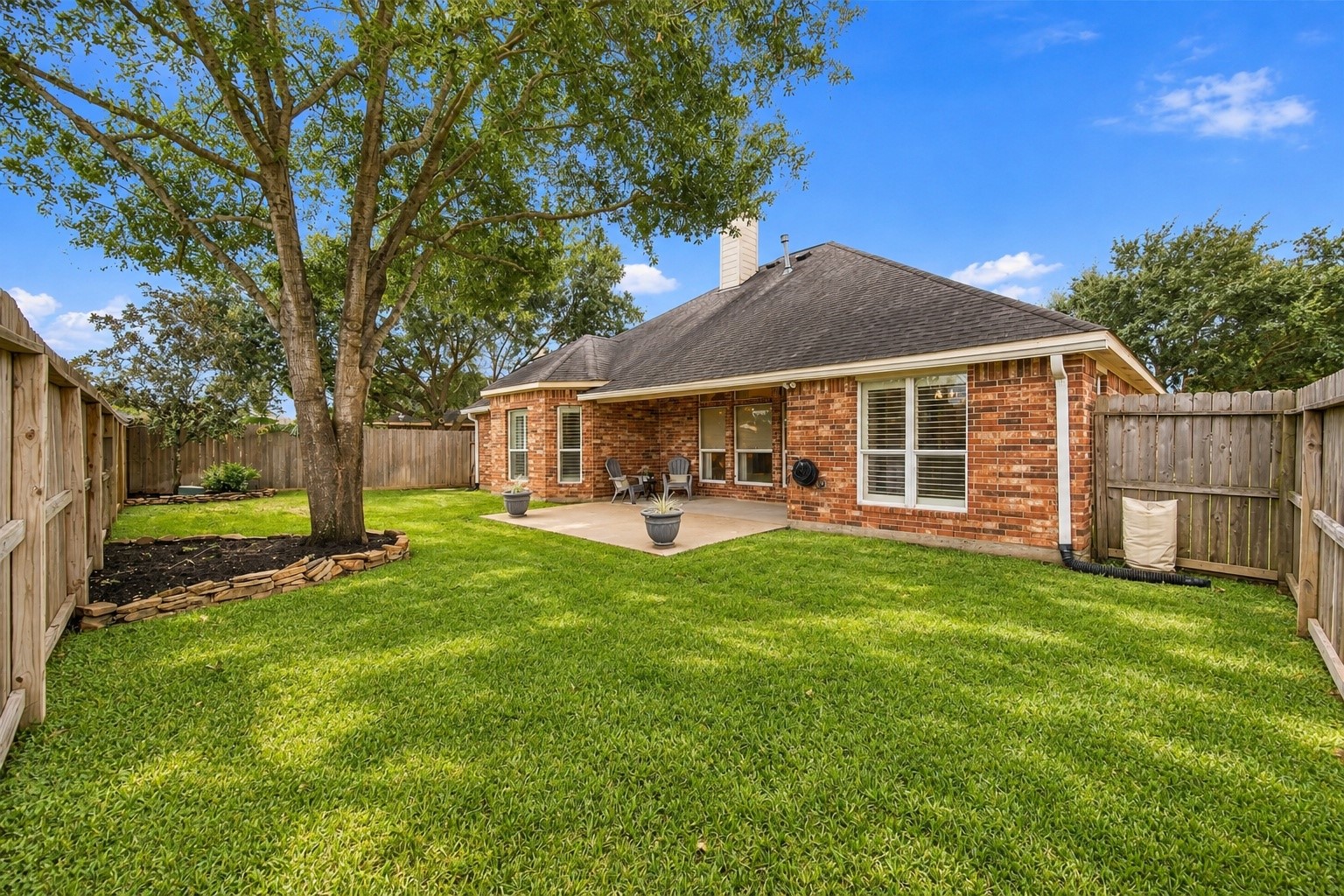 What a nice backyard! This fully fenced yard features a beautiful mature shade tree, space for outdoor activities, and a covered patio for entertaining. And with no rear neighbors, you'll enjoy added privacy!