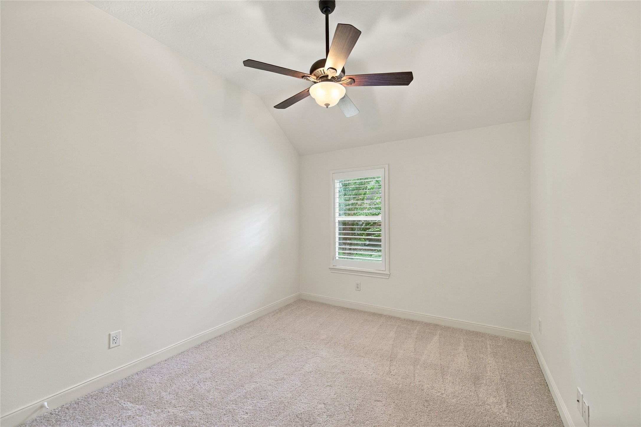 Like the first bedroom, the second of two secondary bedrooms is complete with plantation shutters, fresh paint, new carpet, and lighted ceiling fan.