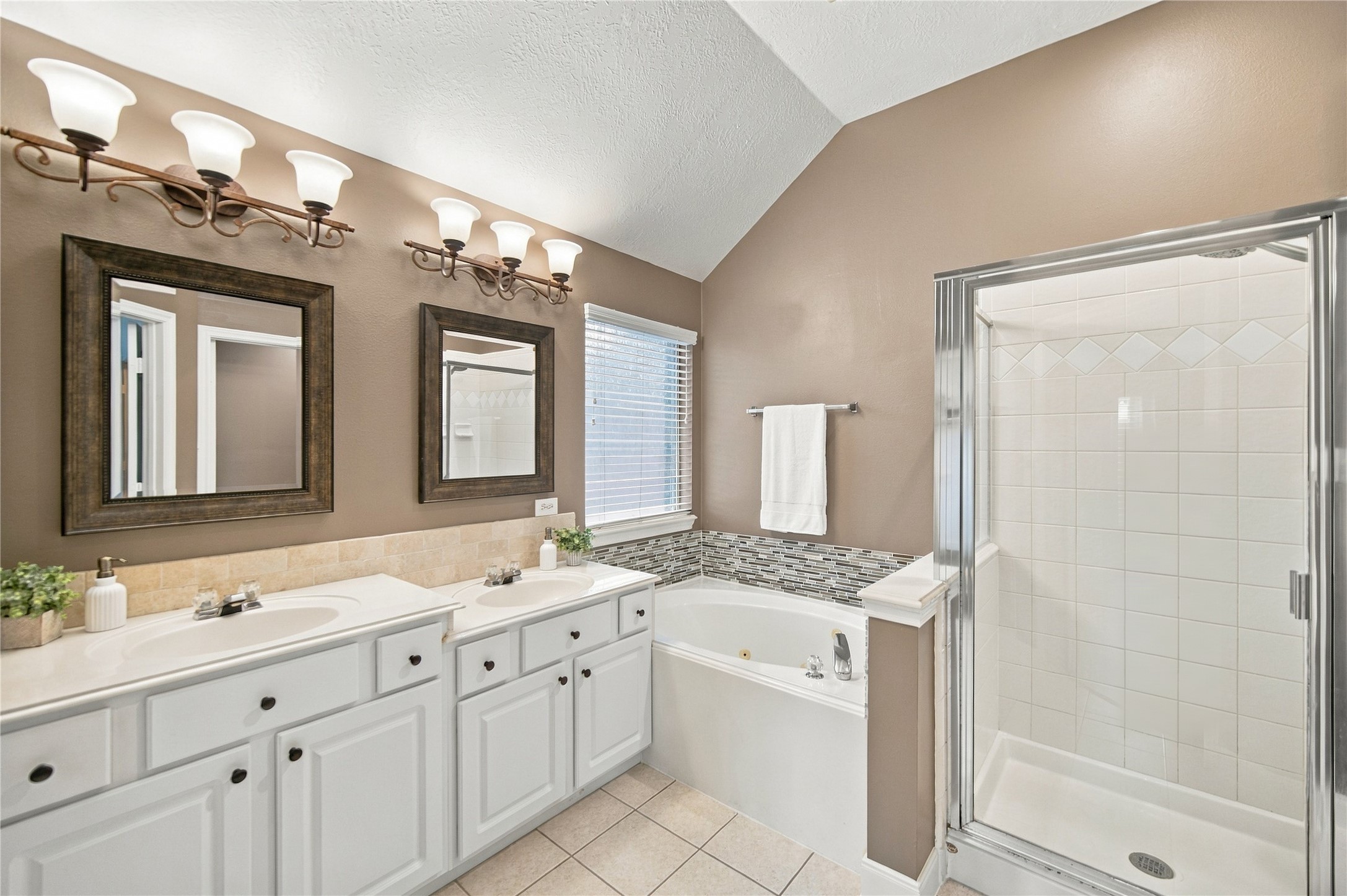 The primary bathroom provides a double-sink vanity, a jetted tub, and a walk-in shower.