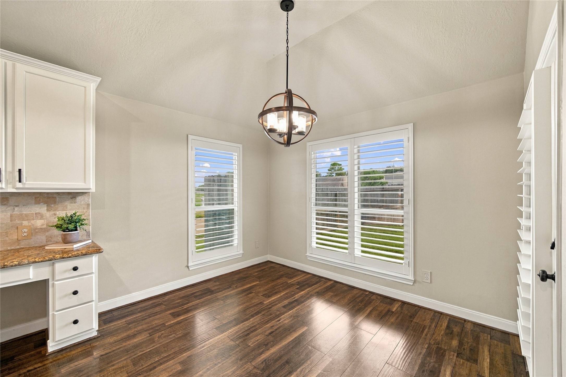 The kitchen flows seamlessly into the breakfast area and family room, creating an inviting space for everyday living and entertaining.  At left is a very convenient built-in desk!