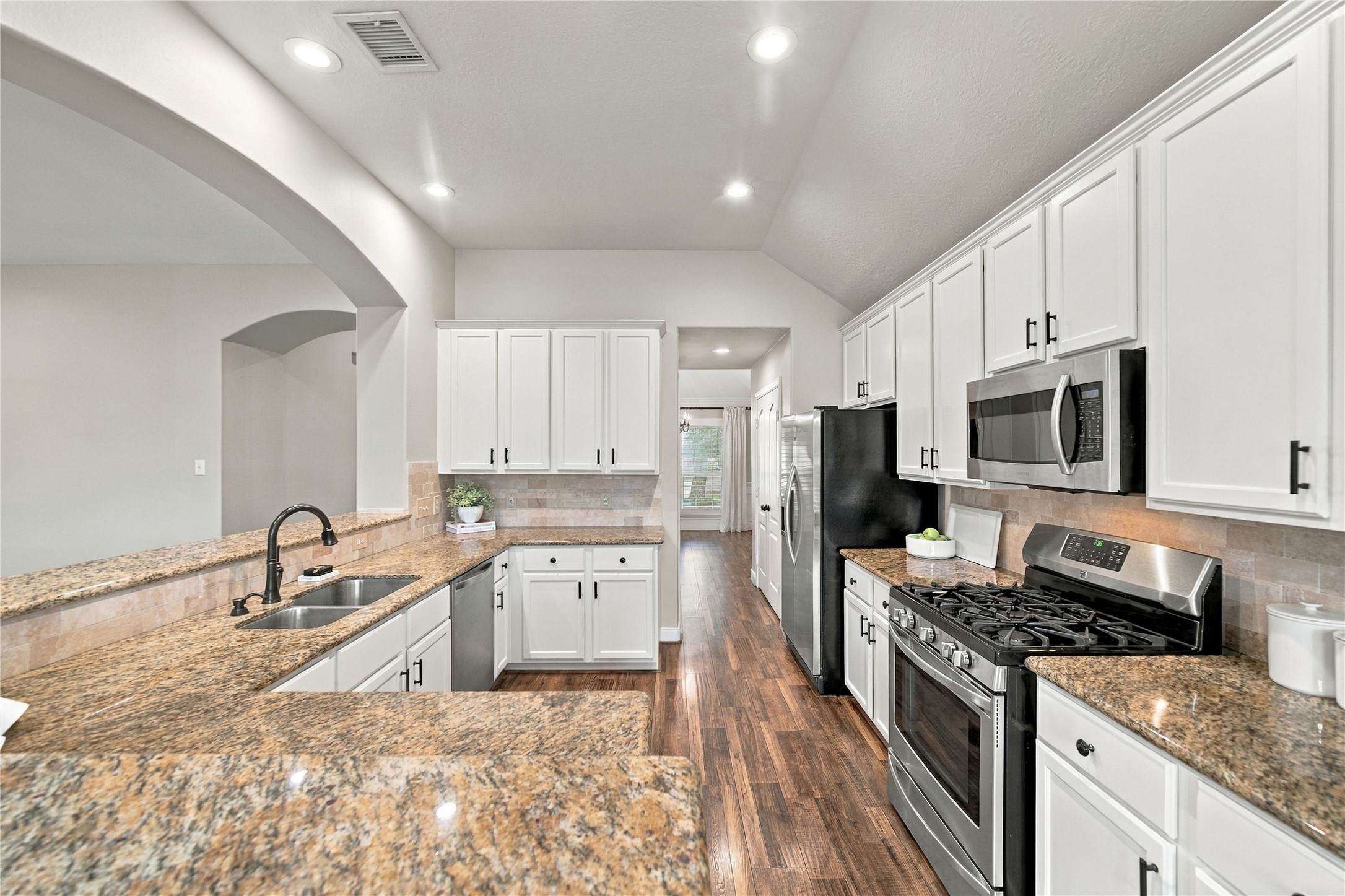 The stainless steel appliances include a five-burner gas range, and the double-door refrigerator is included with the home.