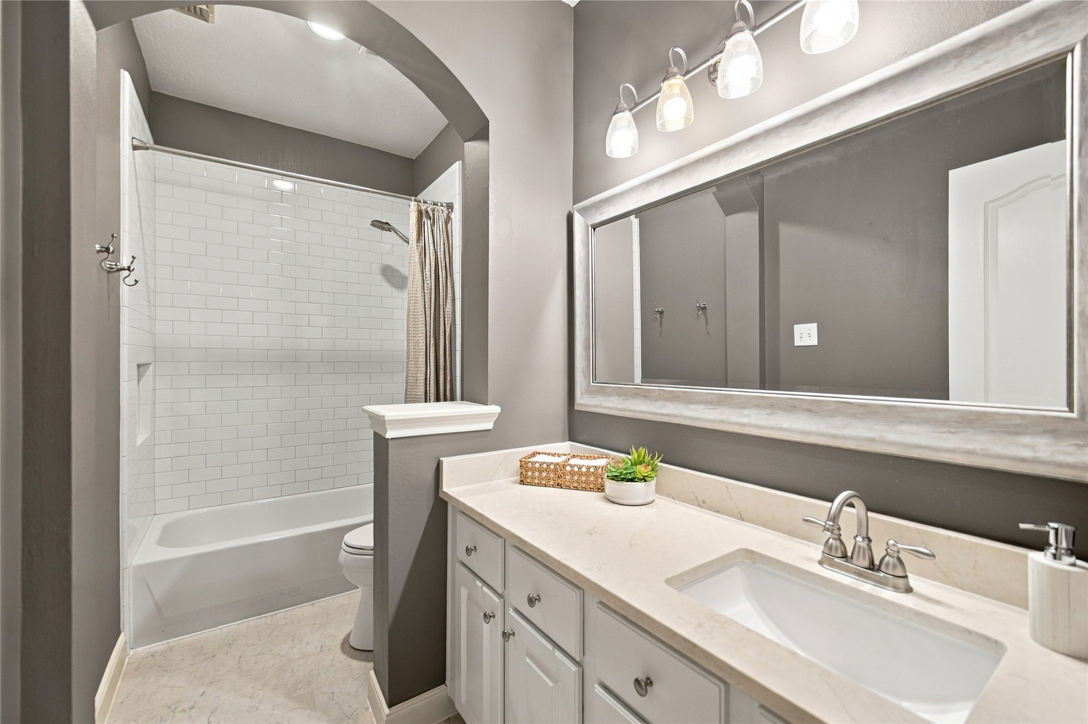 The well-appointed and updated second bathroom is conveniently located in the hallway near the two secondary bedrooms. Just outside the bathroom is a linen closet for additional storage.