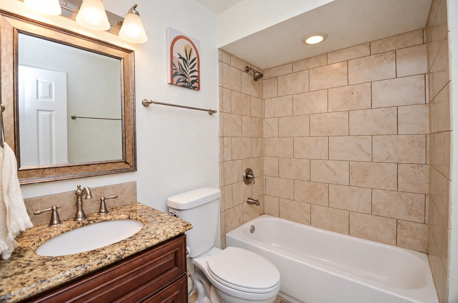 Hallway bathroom with tub/shower and brushed nickel fixtures.
