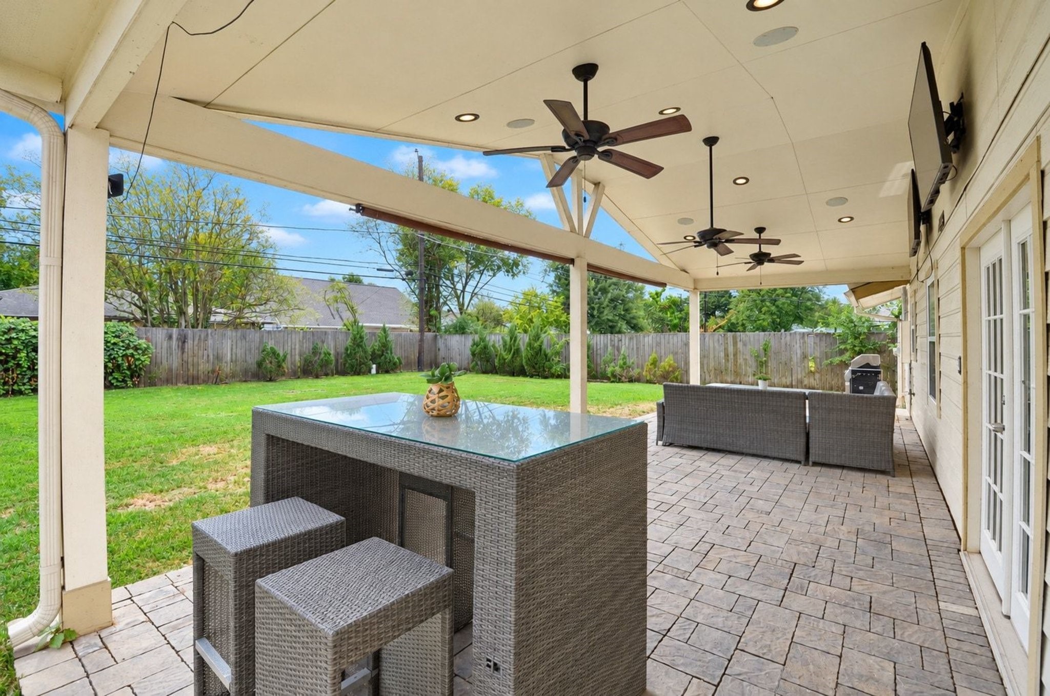 Enjoy outdoor living on this custom covered stone patio complete with overhead ceiling fans and outdoor sound system!