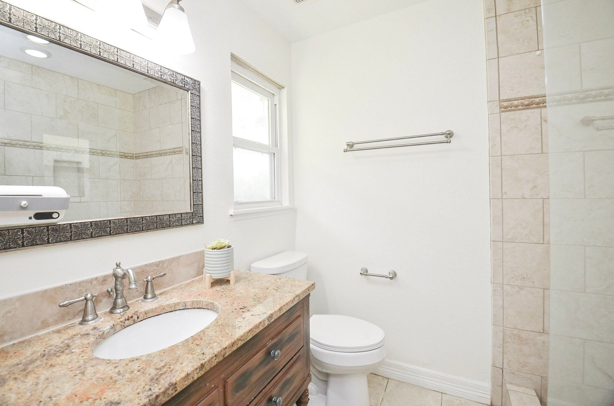 Primary suite with walk-in shower and brushed nickel faucet.