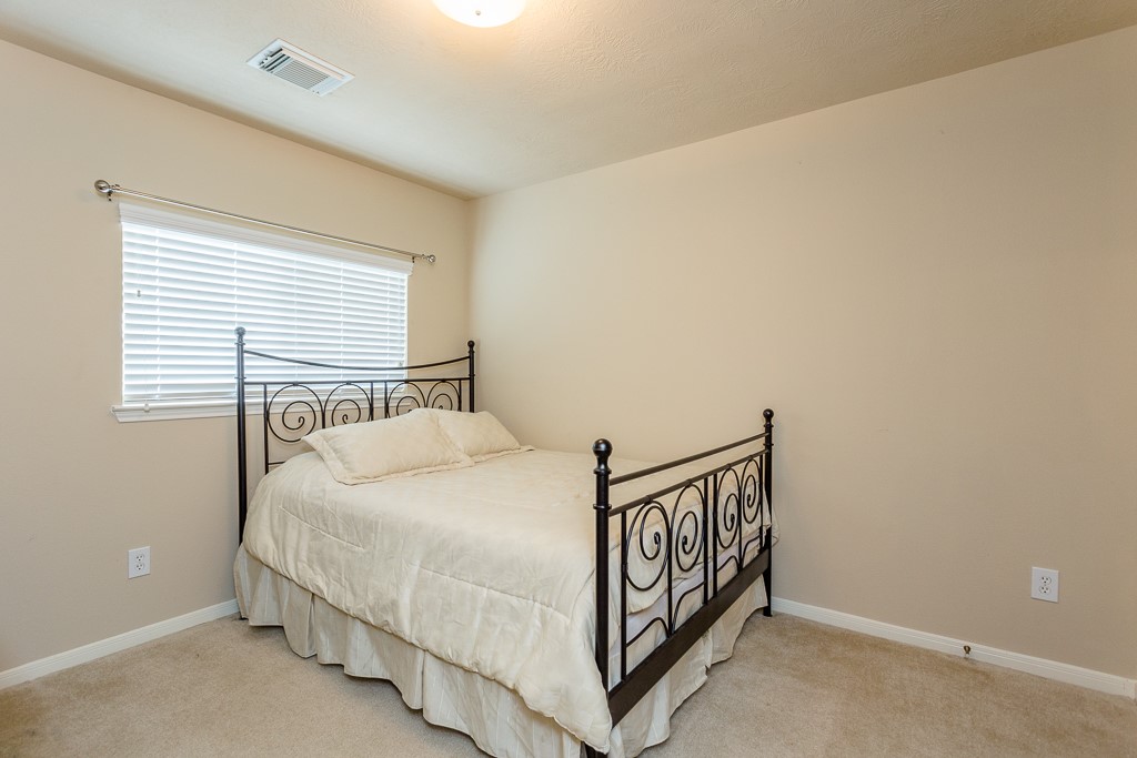 3rd bedroom neutral walls, and ample natural light from a large window.