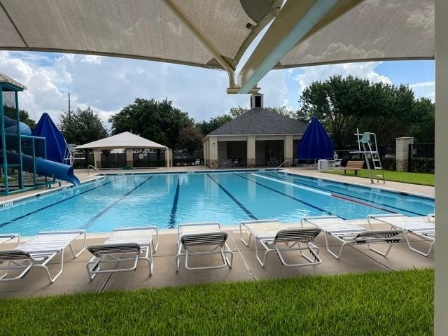 Enjoy relaxing and entertaining at this inviting community pool, complete with a waterslide, shaded seating, and a charming clubhouse.