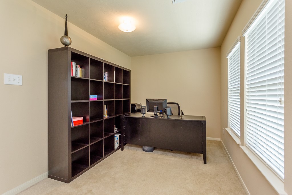 Bright home office featuring large windows, and ample space for productivity.
