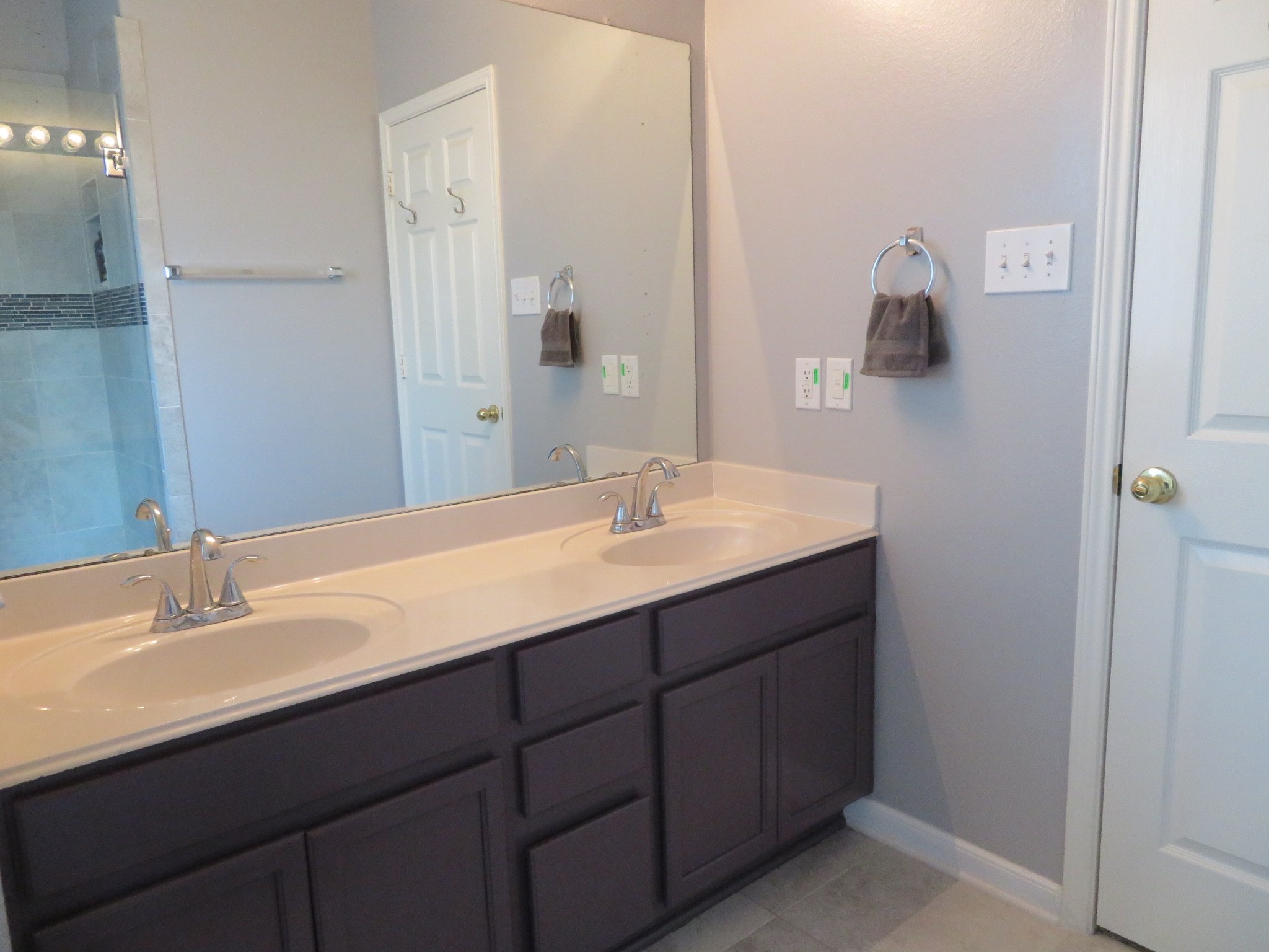Elegant bathroom featuring a dual-sink vanity with modern fixtures, ample storage, and a sleek, seamless mirror.