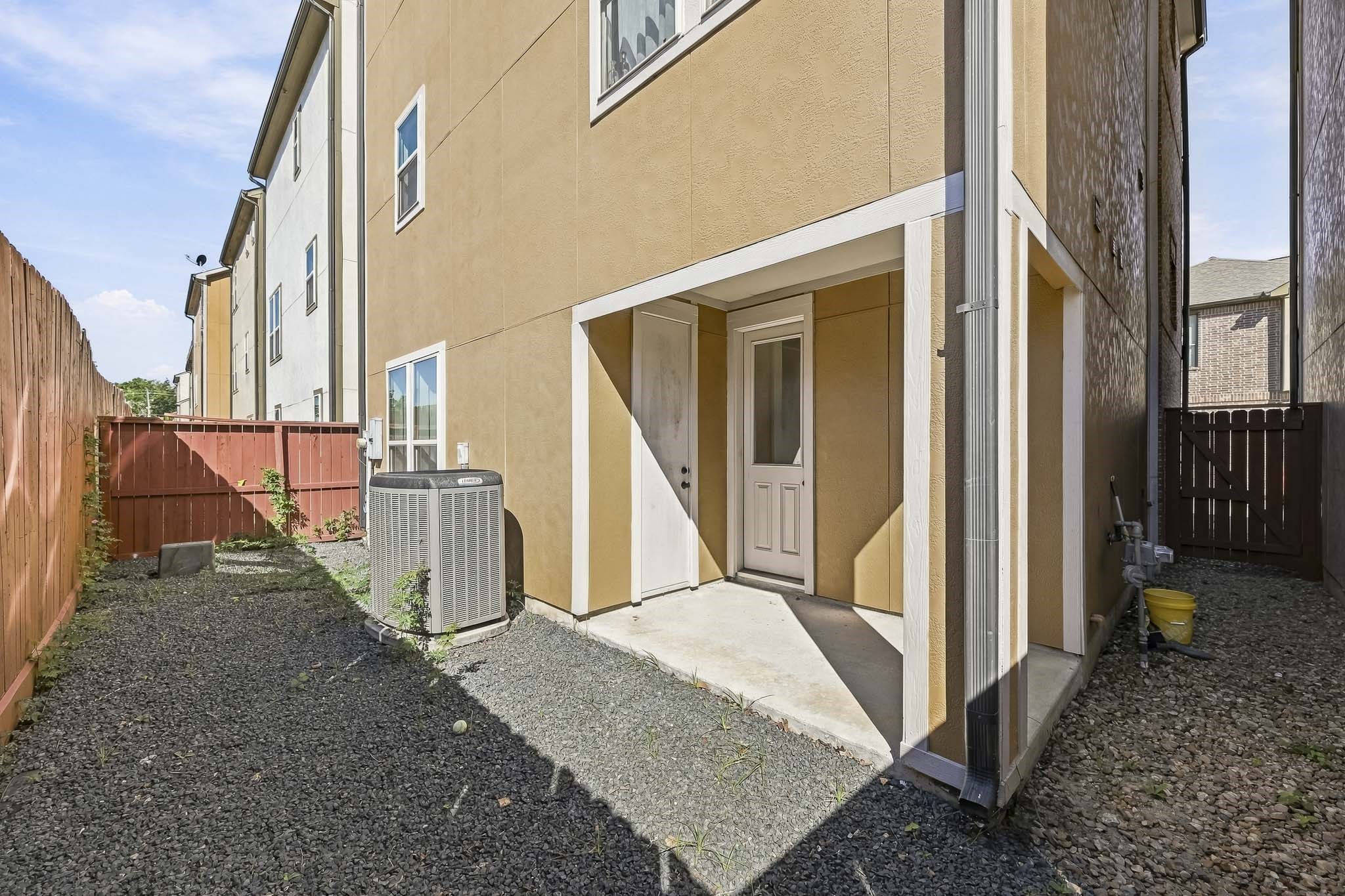 Charming side entrance with a covered patio area, leading to a fenced-in backyard offering privacy and space for outdoor activities.