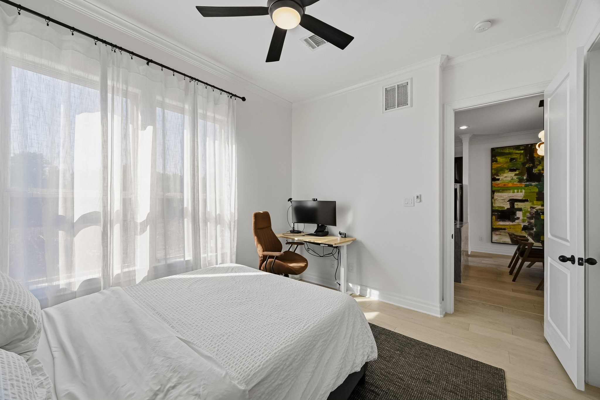 Bright and airy bedroom featuring large windows .