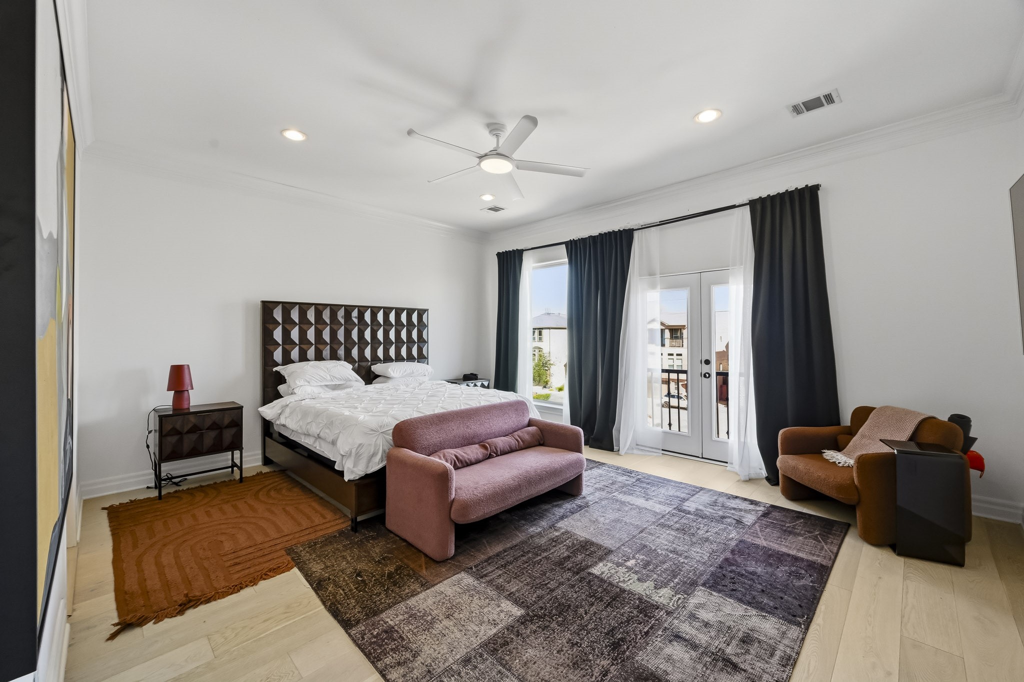 Spacious bedroom featuring elegant French doors leading to a private balcony.