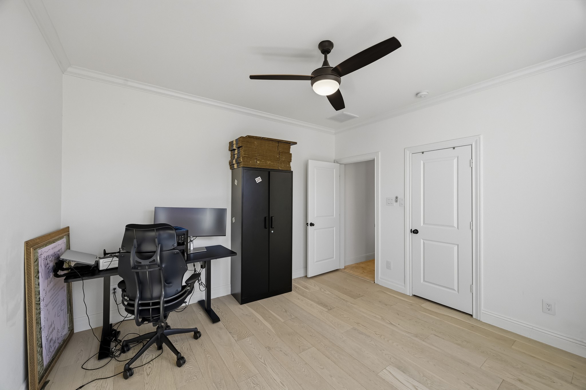 Bright and spacious room with light wood flooring, and ample space for a home office setup.