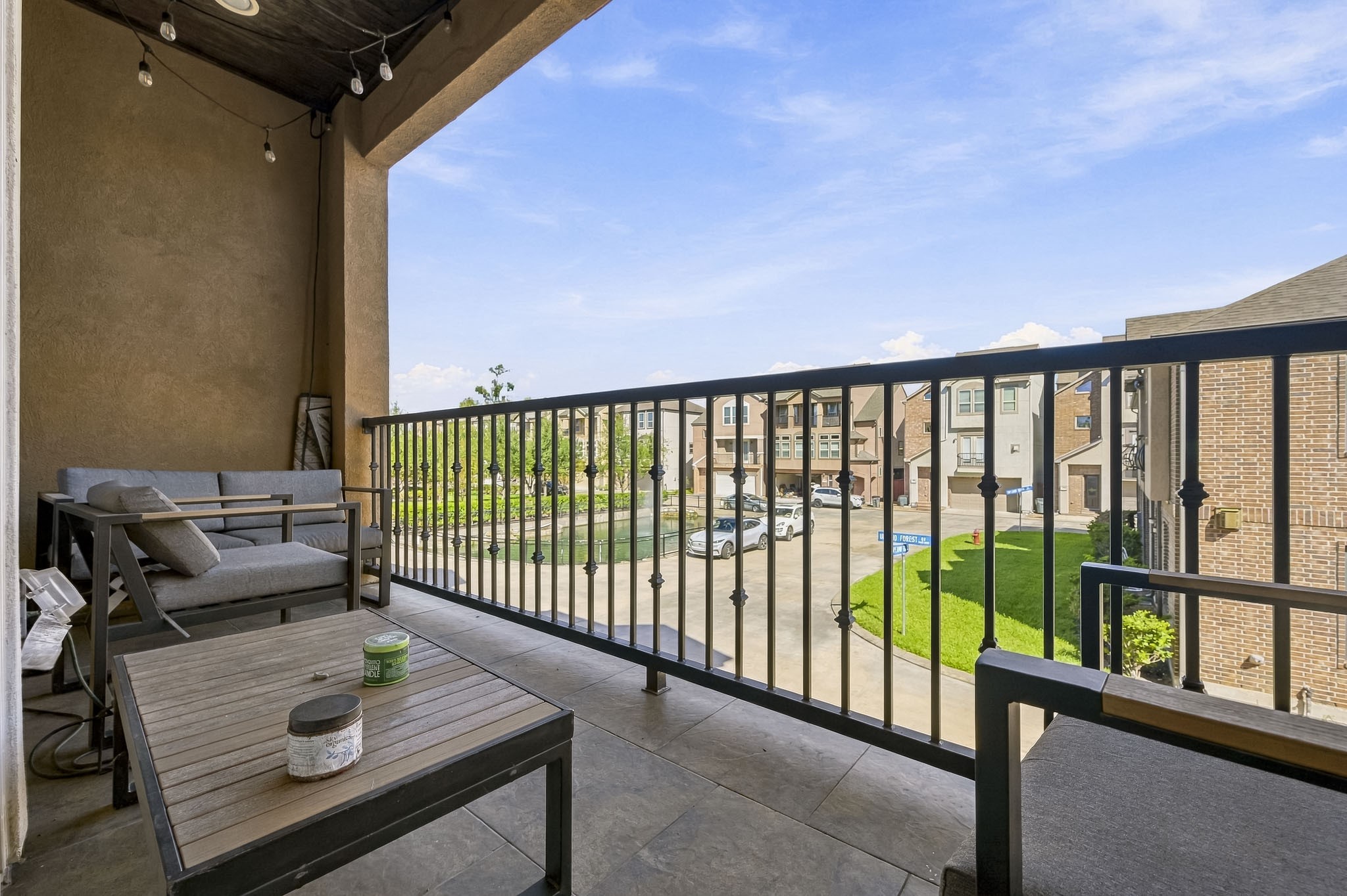 Charming balcony offering a cozy seating area with stylish outdoor furniture, overlooking a serene neighborhood view. Perfect for relaxation and enjoying the fresh air.