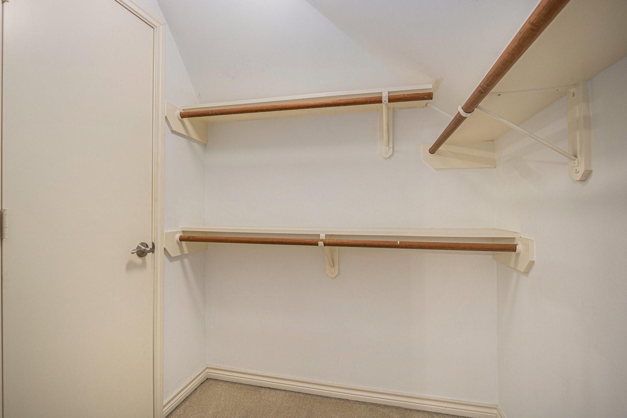This photo shows a spacious walk-in closet with built-in shelves and hanging rods, offering ample storage space.