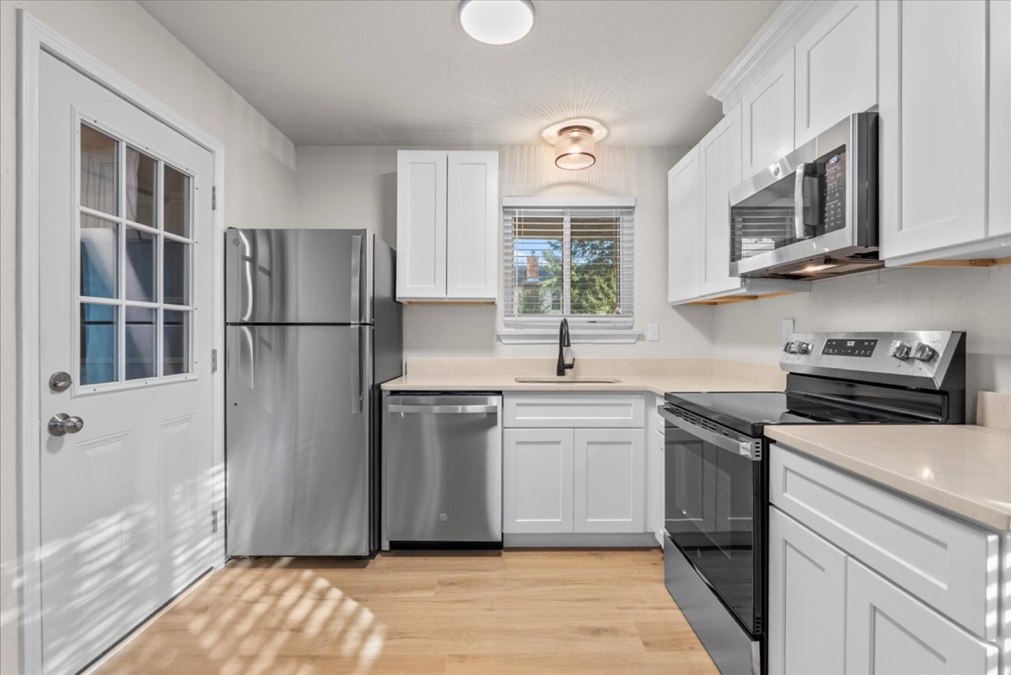 Extensively remodeled kitchen boasting sleek quartz countertops and soft-close cabinetry and drawers.