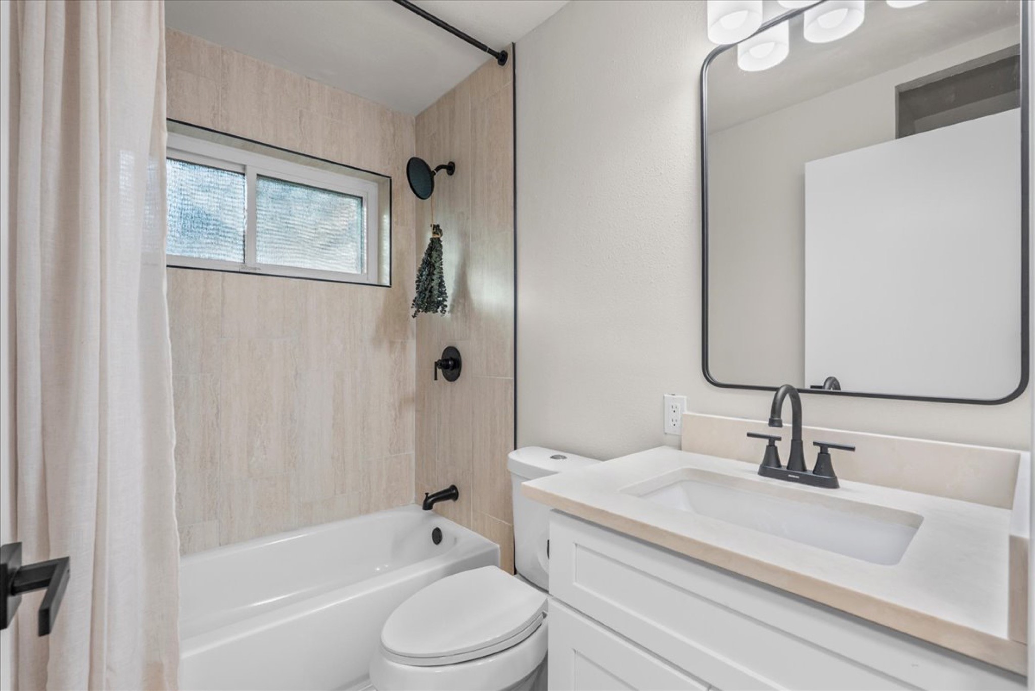 The full bath features a fresh tub/shower combo highlighted by clean, contemporary tile work.