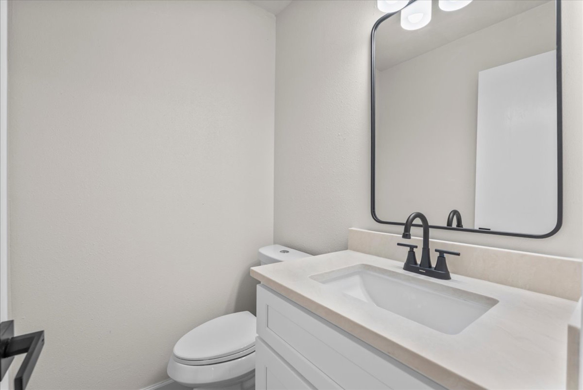 Fully updated half bath equipped with a new quartz-topped vanity and modern plumbing fixtures.