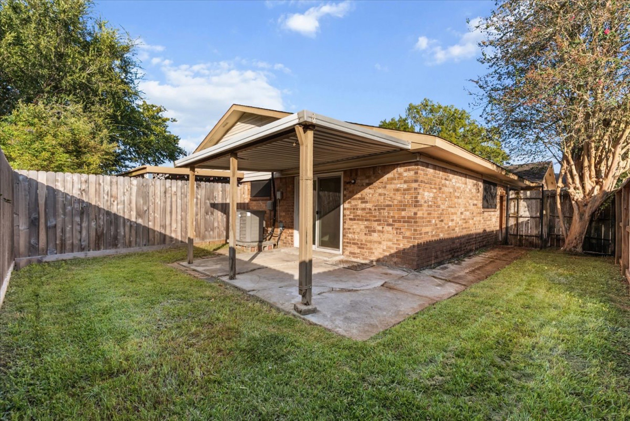 Private fenced back patio and yard area ideal for morning coffee, pets, and outdoor dining.
