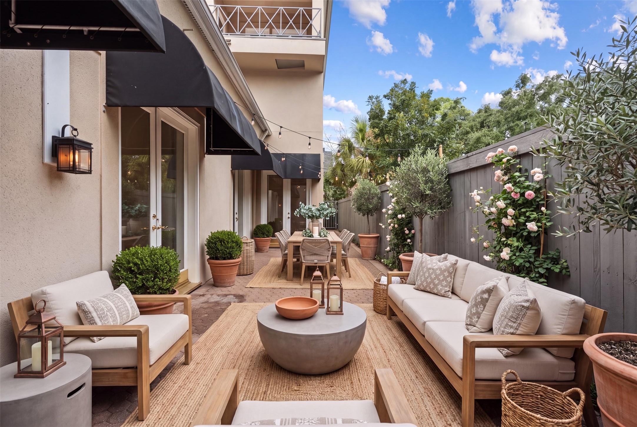 Welcome home to this lovely entry courtyard perfect to relax for a morning cup of coffee or entertain guest. This home has both front and back terraces. AI generated photo. Black canopies and paver terrace do exist. New exterior paint and new exterior light fixtures.