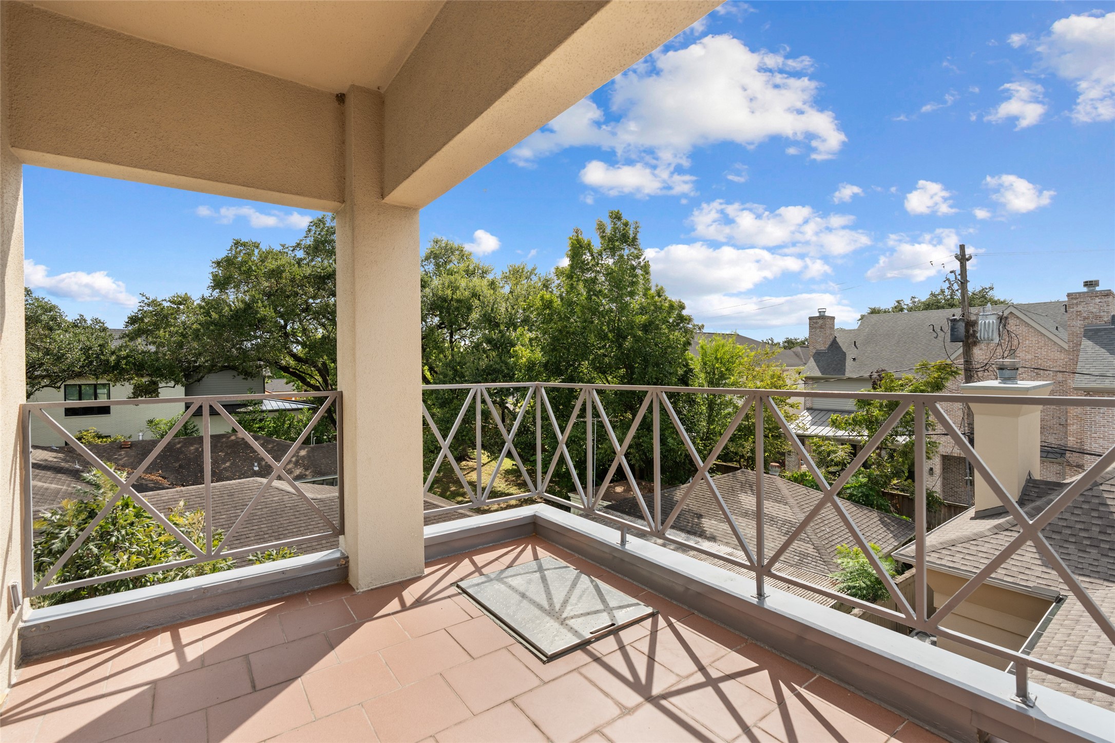 Spacious balcony with a charming view of lush trees and rooftops, perfect for enjoying the outdoors. Fire excape ladder built in.