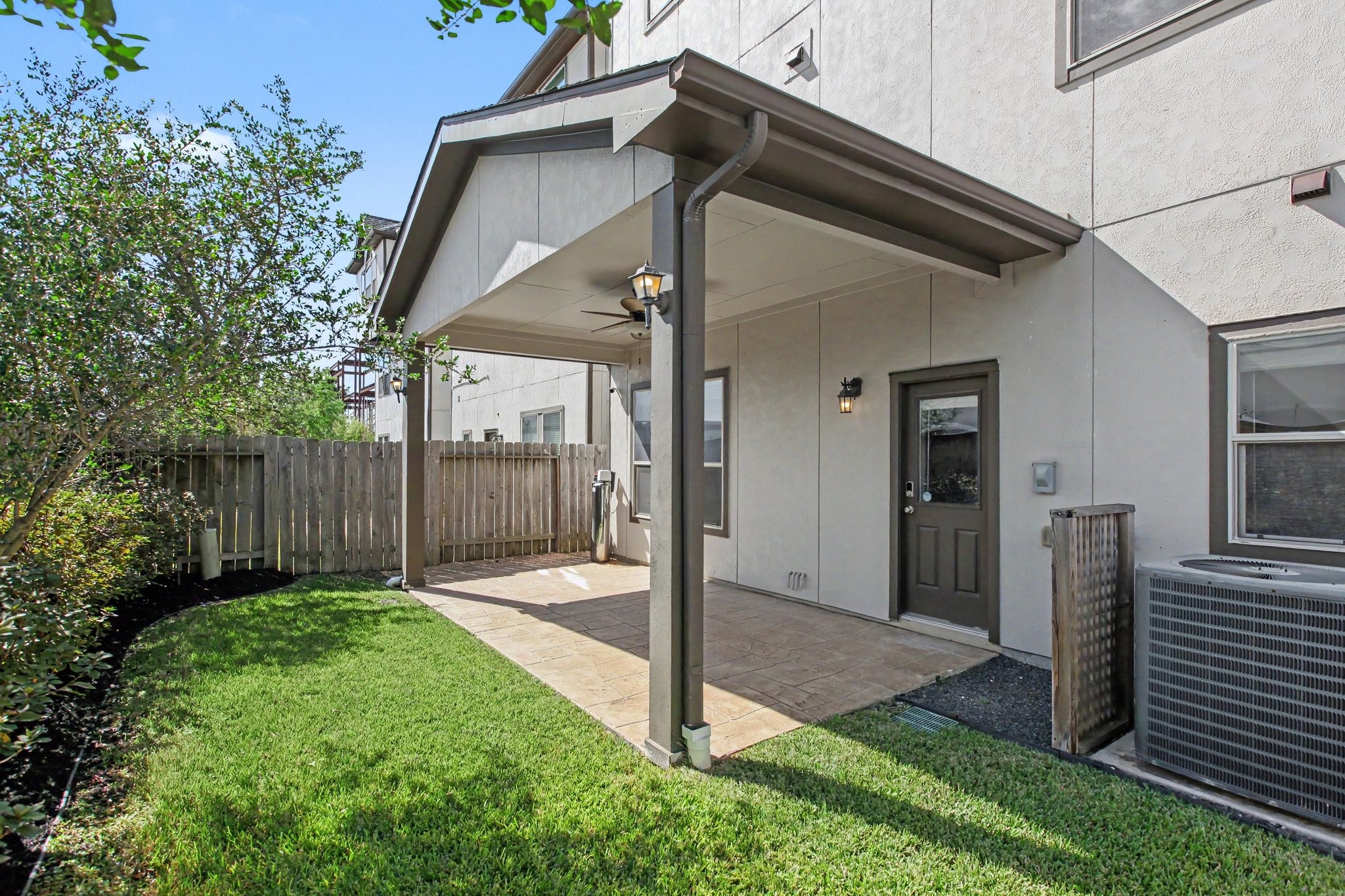 The backyard covered patio with lighting and ceiling fan