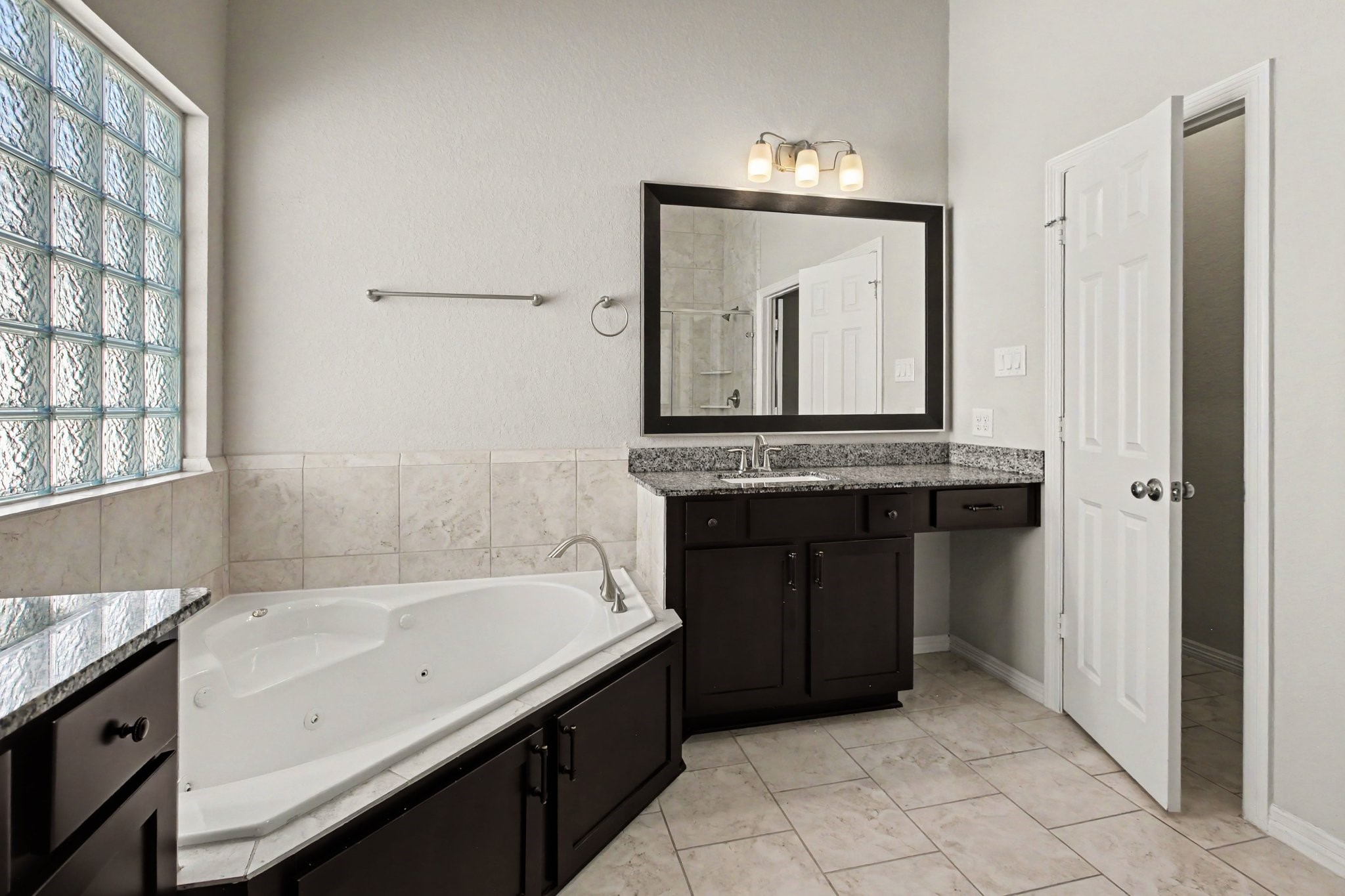 Primary bathroom with double vanities, bathtub and walk-in shower