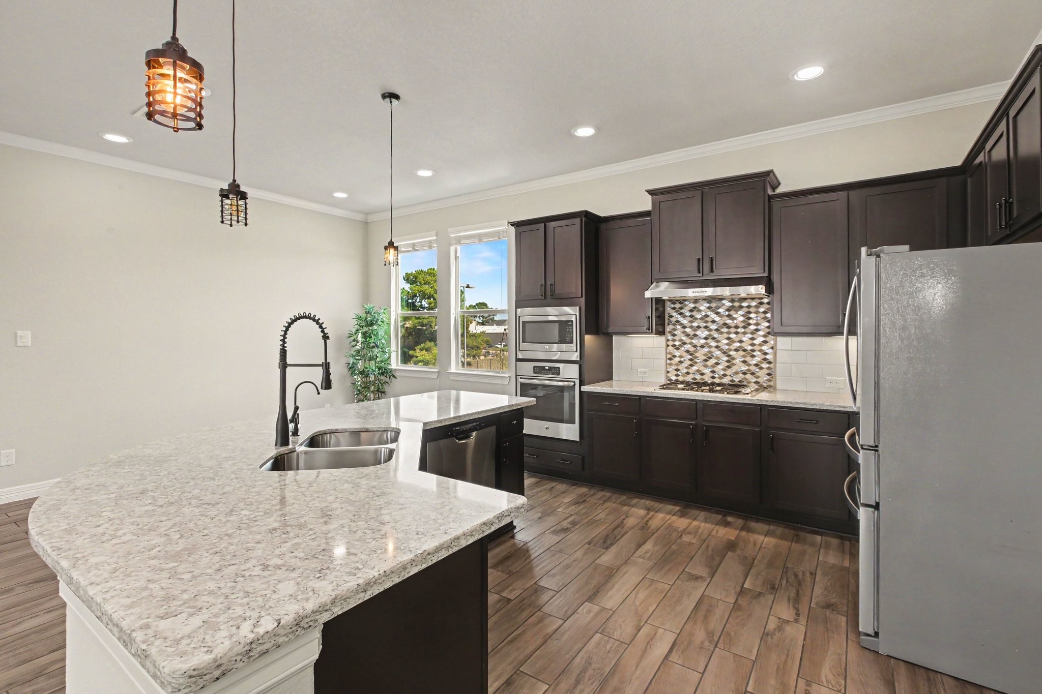Spacious, open kitchen with large island, granite countertops, and stainless steel appliances