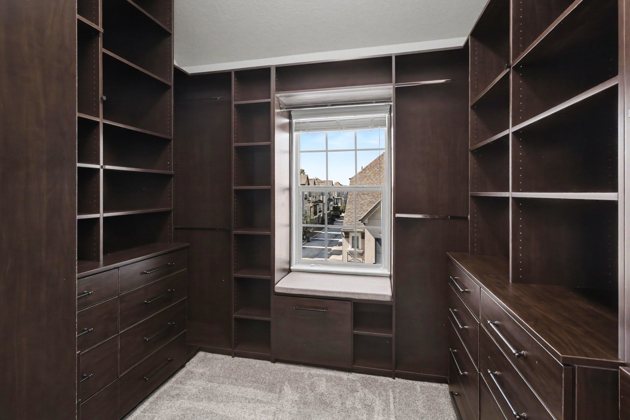 Custom-designed walk-in closet with abundant shelving, cabinetry, and drawer storage