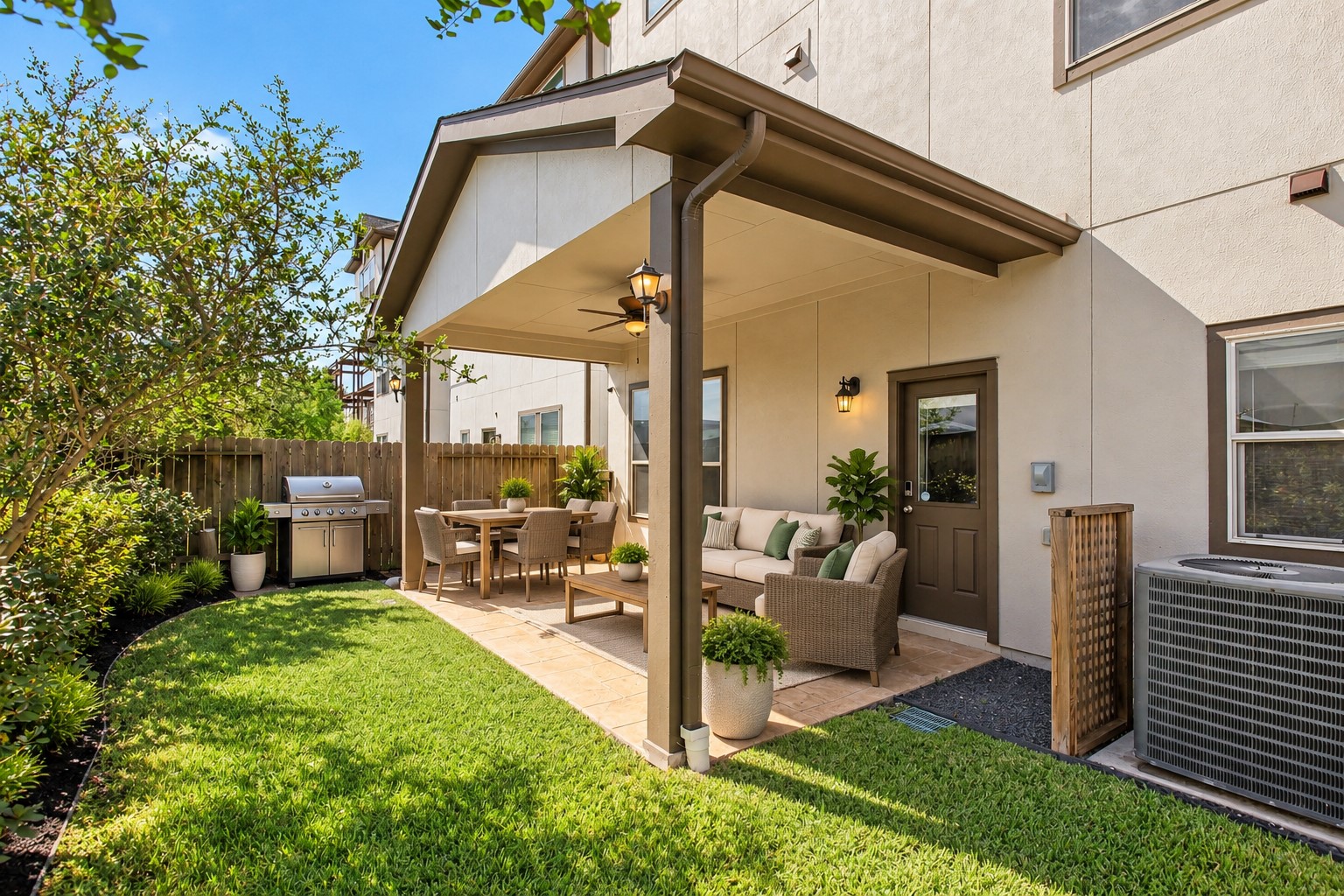 The backyard covered patio with lighting and ceiling fan (virtually staged)