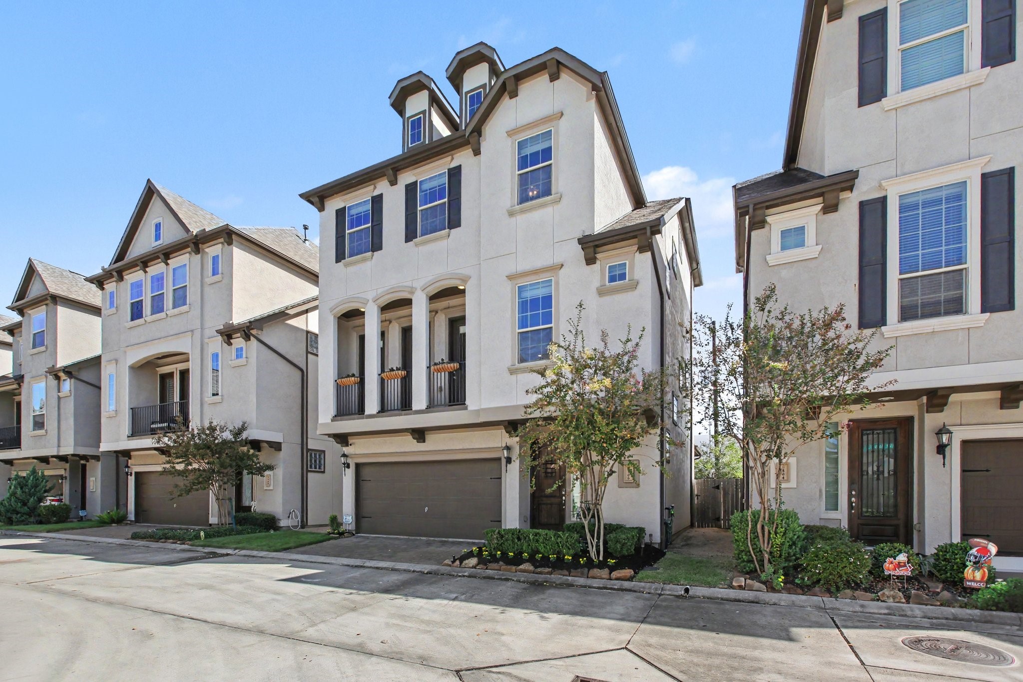 Elegant three-story home featuring a charming covered balcony, attractive architectural details