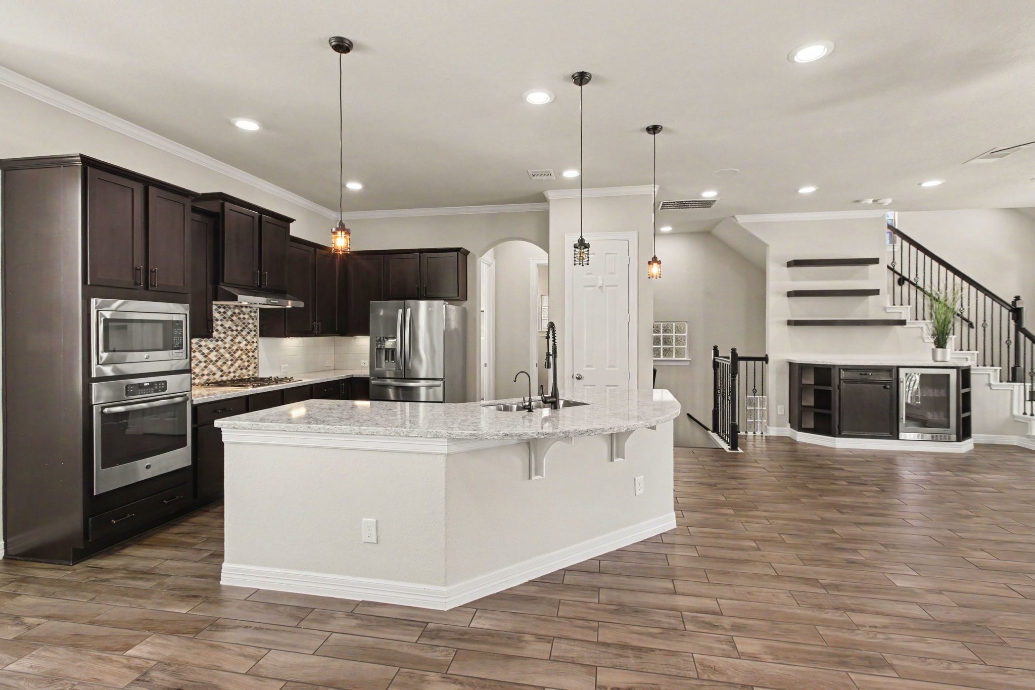 Spacious, open kitchen with large island, granite countertops, and stainless steel appliances