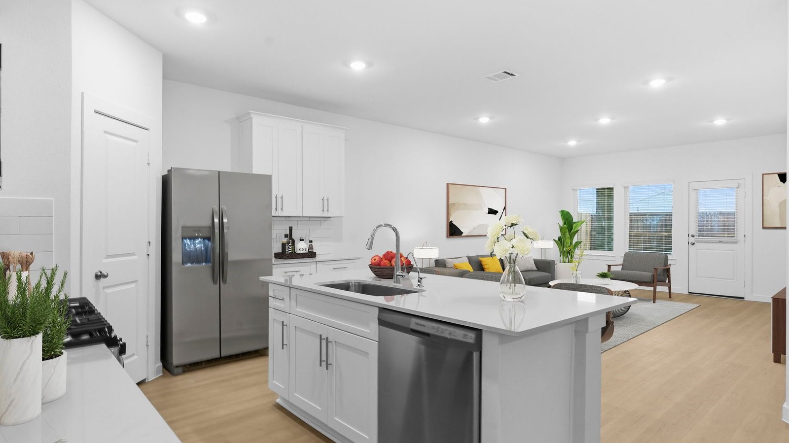 An open concept kitchen with an island with bar seating and access to the living and dining areas. An open concept kitchen with an island with bar seating and access to the living and dining areas.