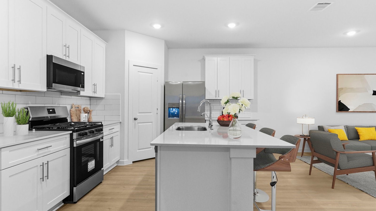 Kitchen adorned with painted cabinets seamlessly integrated into an open dining area layout. Kitchen adorned with painted cabinets seamlessly integrated into an open dining area layout.
