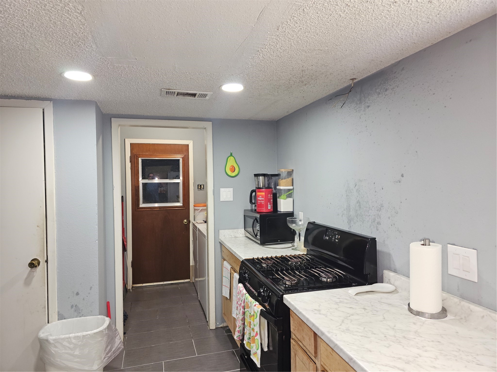 Kitchen features updated countertops, gas cooking, and a functional layout with easy access to the utility area.