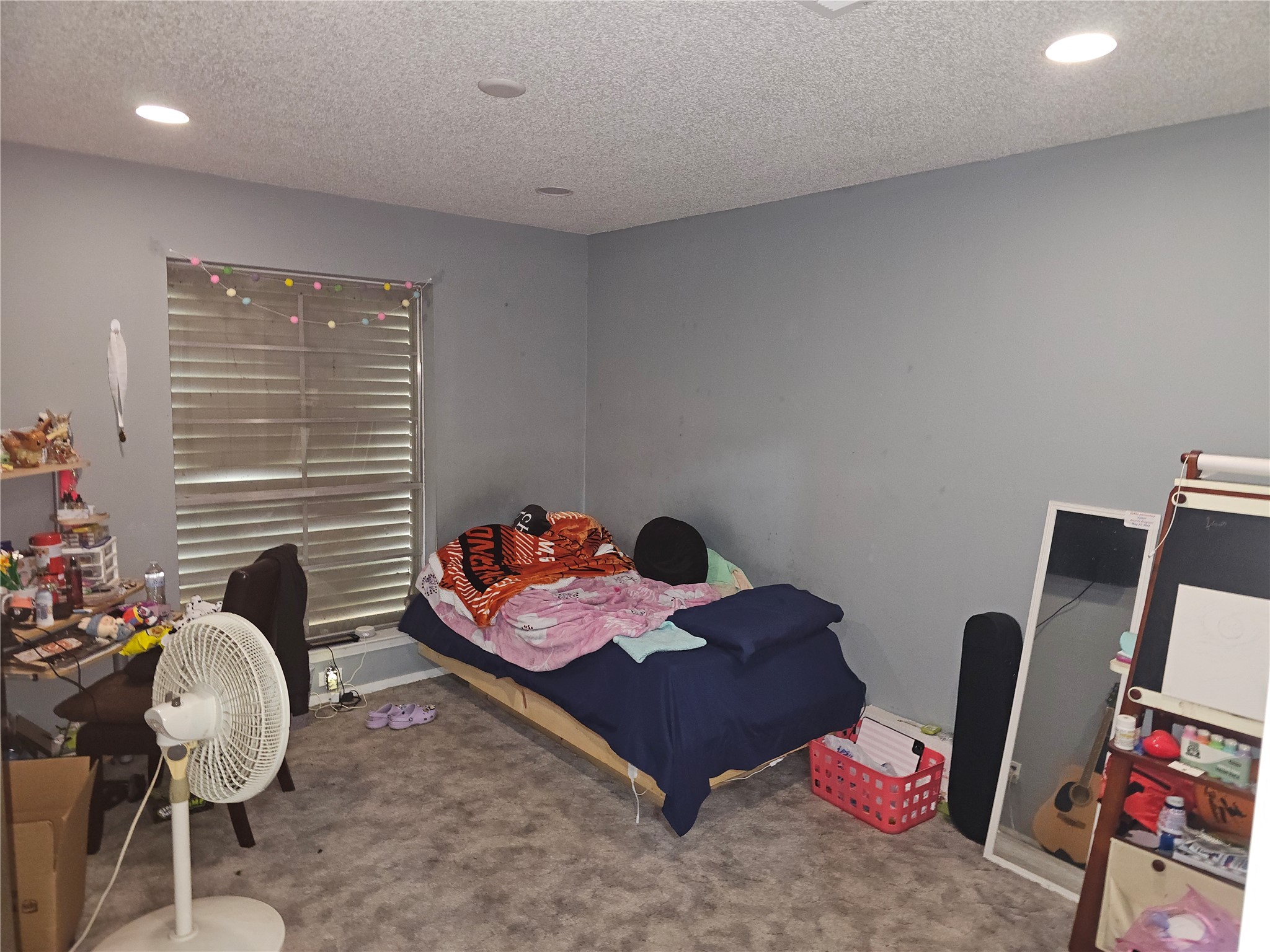 Secondary bedroom with plush carpeting, recessed lighting, and a large window for natural light.