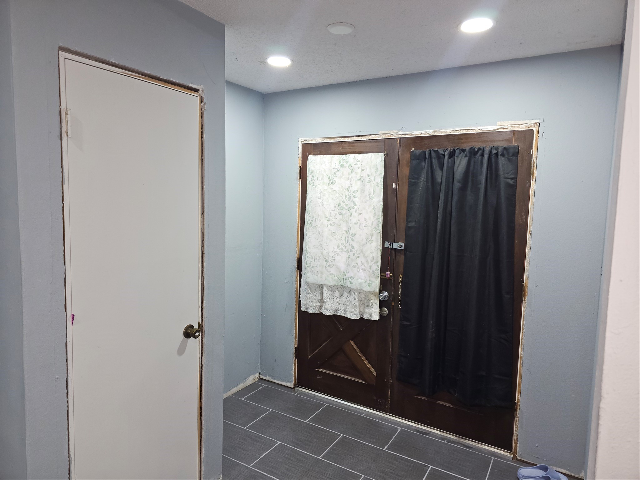 Inviting foyer with updated tile flooring offers a functional and welcoming entrance to the home.