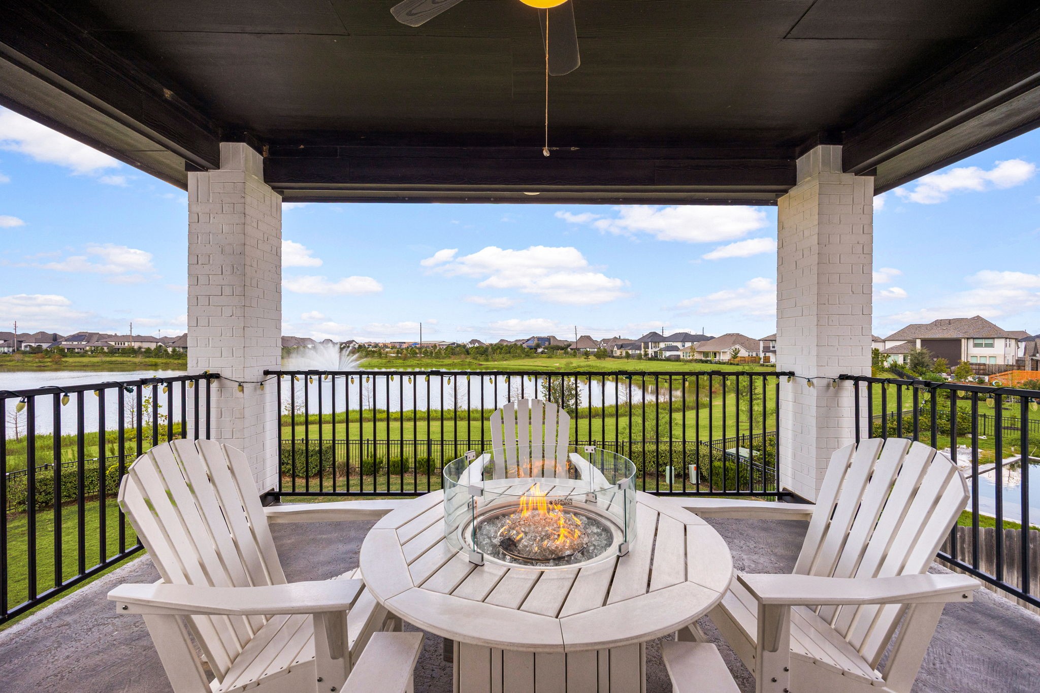 Elevate your outdoor living experience with a private second-floor retreat overlooking serene lake views, complete with inviting lounge seating and a central fire pitthe perfect setting to unwind in luxury.