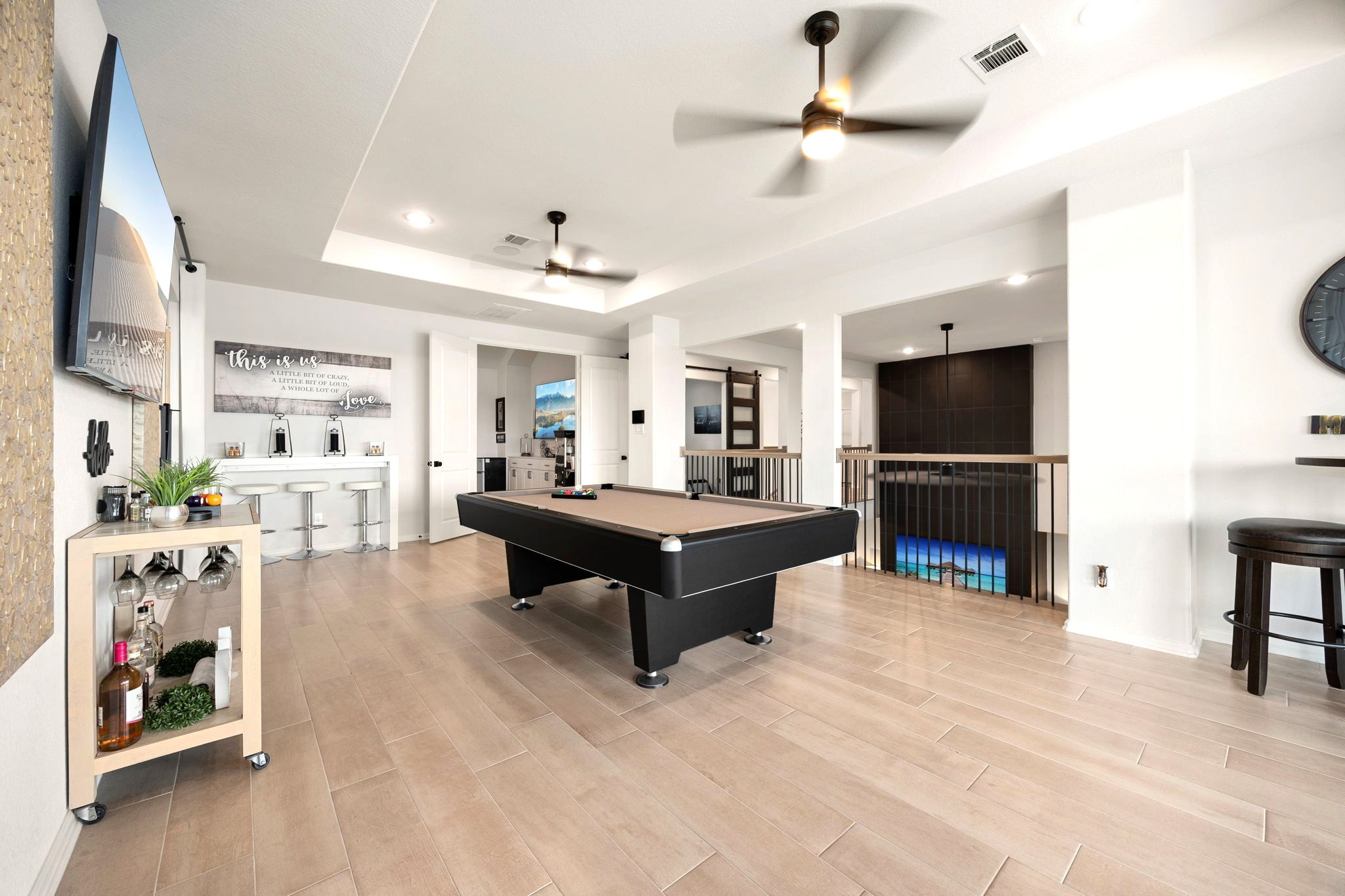 The spacious upstairs game room offers a seamless transition to a dedicated theater room through elegant double doors, creating the ultimate entertainment experience for movie nights, game days, and gatherings with family and friends.