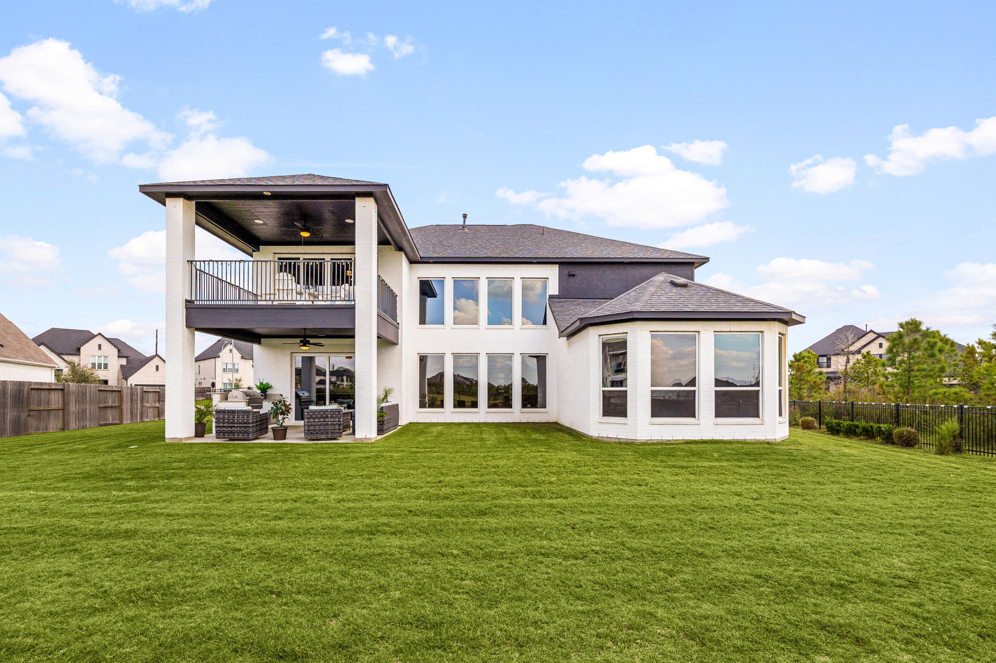 A stunning waterfront perspective showcasing expansive backyard space, elegant first- and second-floor patios, and generous side-yard spaceall designed to embrace outdoor living, serene lake views, and exceptional entertaining.