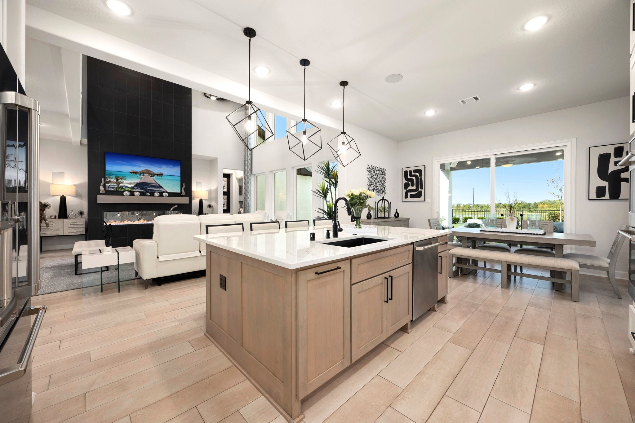 A stunning Omega stone island with custom paneling and cabinetry serves as the centerpiece of the upgraded kitchen, overlooking the open-concept living and dining areas with expansive sliding glass doors that seamlessly connect indoor elegance with outdoor entertaining.