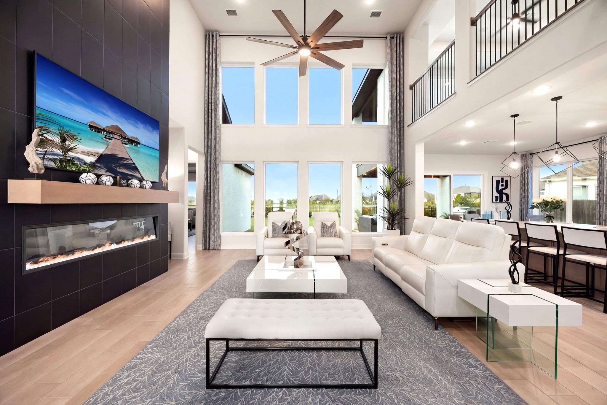 Soaring two-story ceilings and eight expansive windows create a breathtaking living space filled with natural light and beautiful lake views. Window tinting helps manage afternoon sun while allowing you to enjoy the stunning scenery.