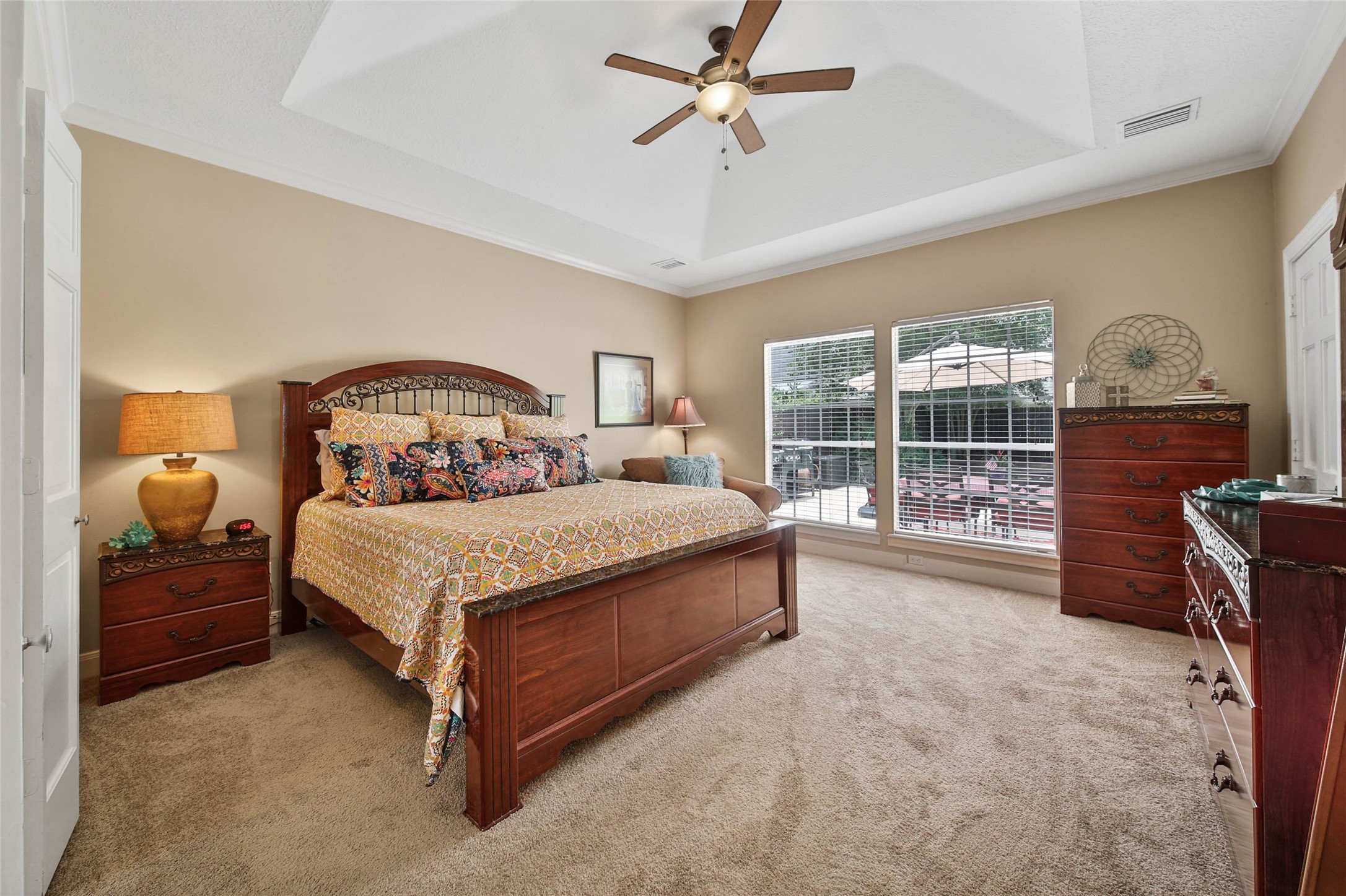 First-floor primary suite offers generous proportions, tray ceiling and backyard views.