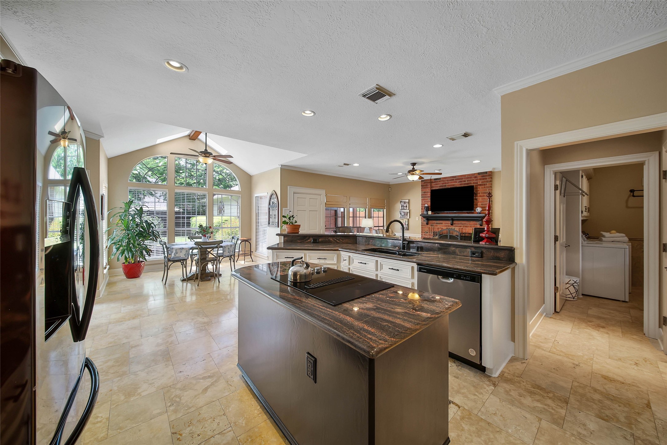 Spacious kitchen with abundant cabinetry, island workspace, breakfast bar and open views toward the home's everyday gathering spaces.
