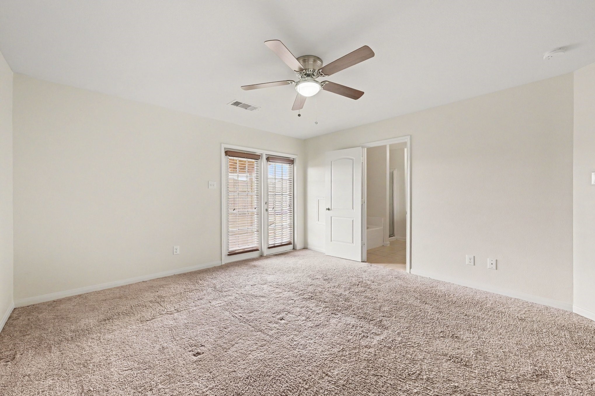 Primary Suite that features large windows with welcoming natural light.