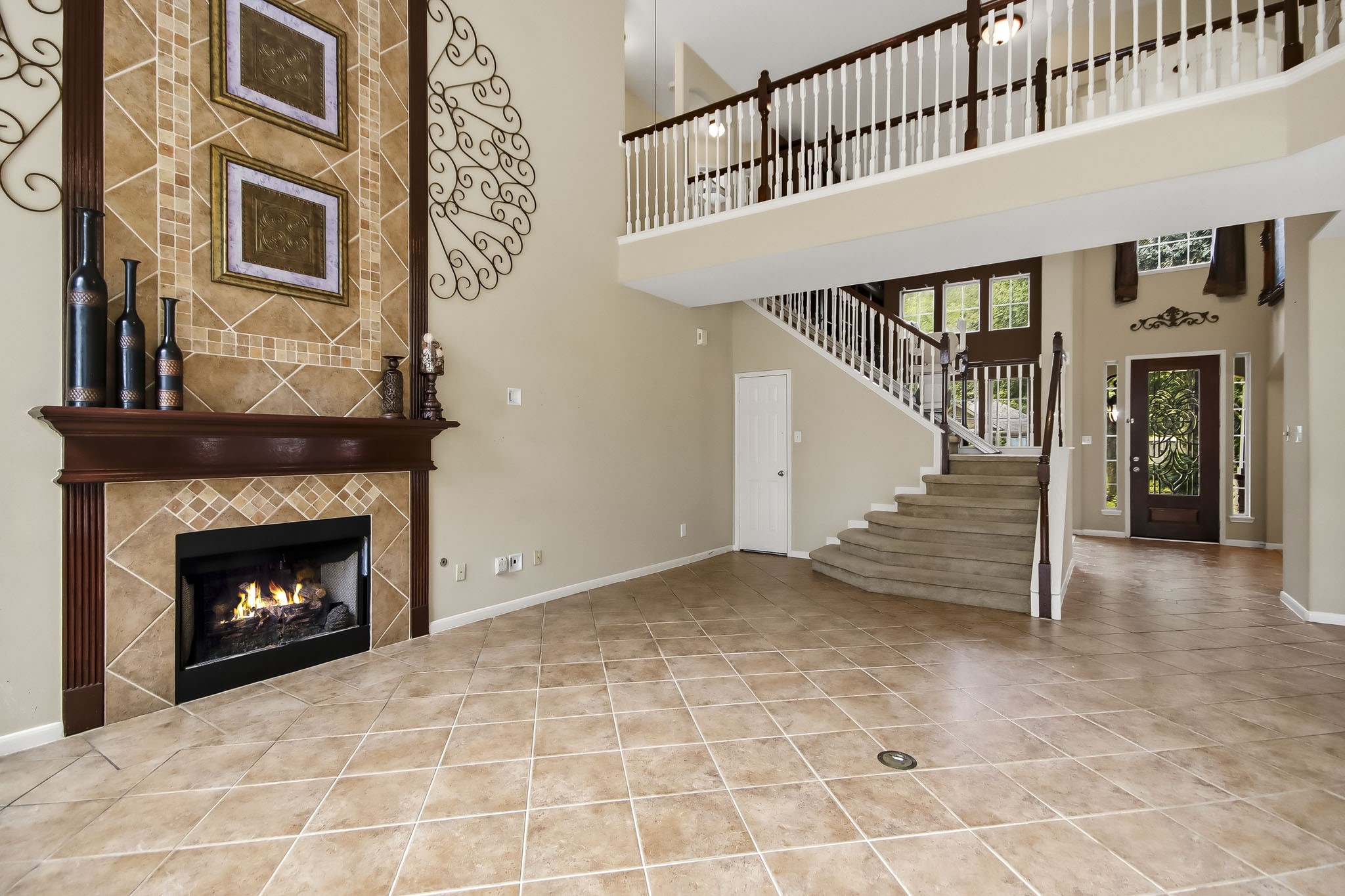 Impressive two-story living area featuring soaring ceilings, abundant natural light, and a beautiful fireplace, creating a grand yet inviting space for relaxing and entertaining.