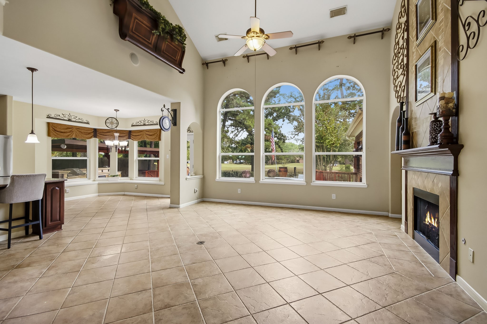 Impressive two-story living area featuring soaring ceilings and an open-concept design that flows seamlessly into the kitchen and charming breakfast nook.
