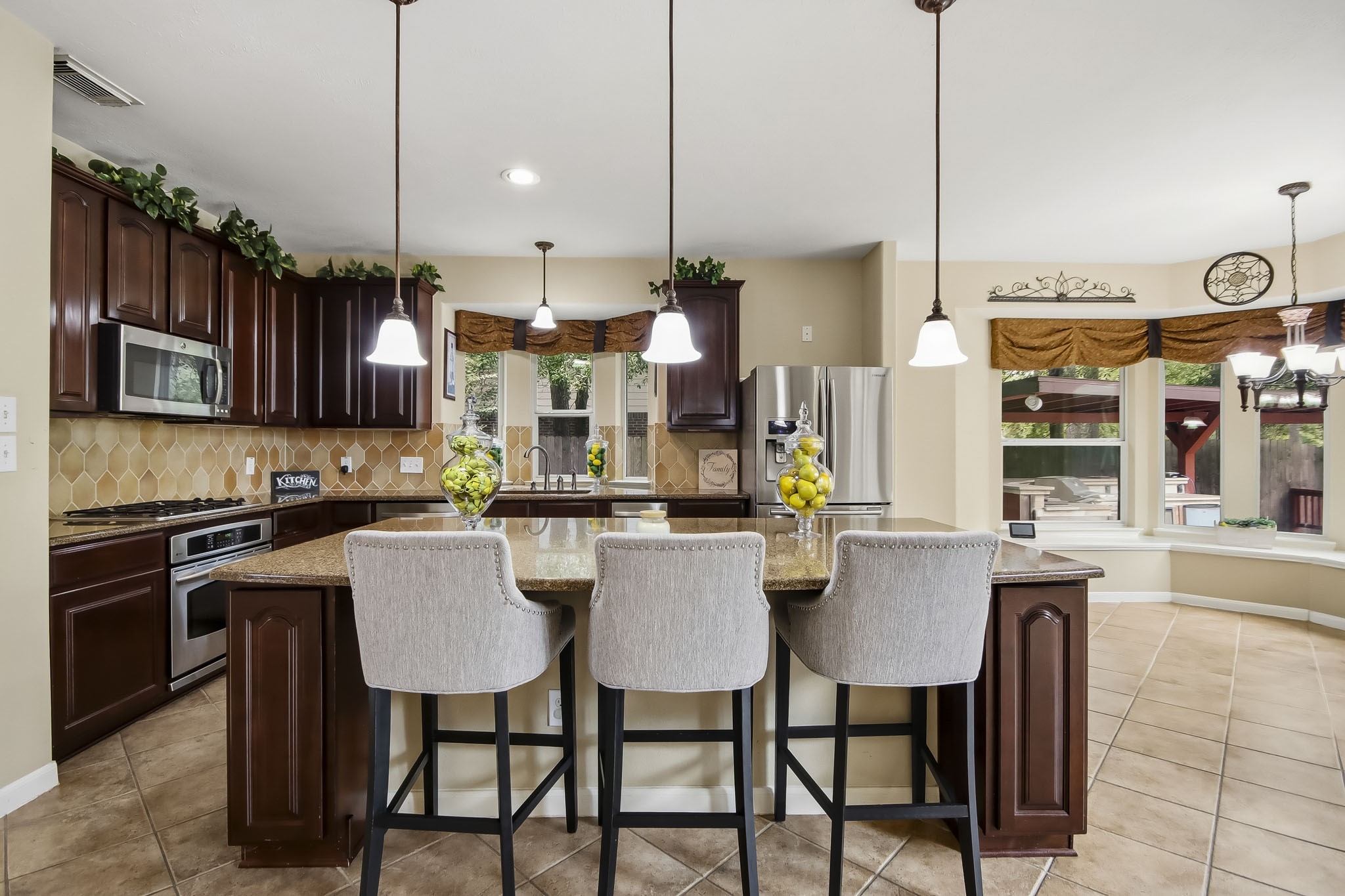 Beautiful open-concept kitchen featuring elegant pendant lighting and a seamless flow into the spacious living area and charming breakfast nook, perfect for everyday living and entertaining!